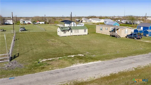 a view of a house with a big yard and sitting area