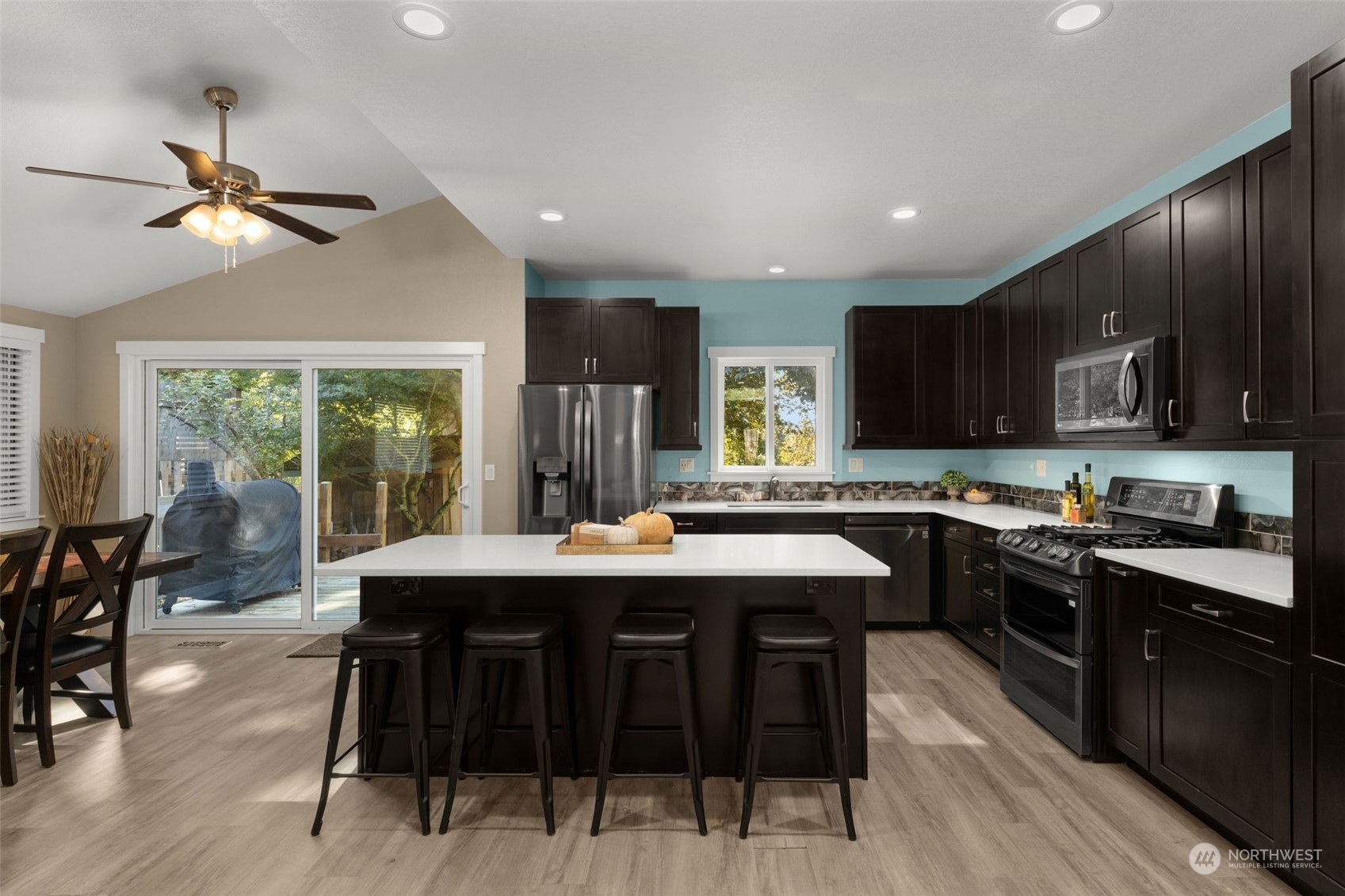 17547 Southeast 135th Street Renton, WA 98059 - Photo 14 of 37 a kitchen with stainless steel appliances granite countertop a stove top oven a sink dishwasher a dining table and chairs with wooden floor