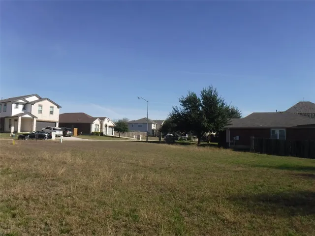 a view of a large house with a yard and large trees