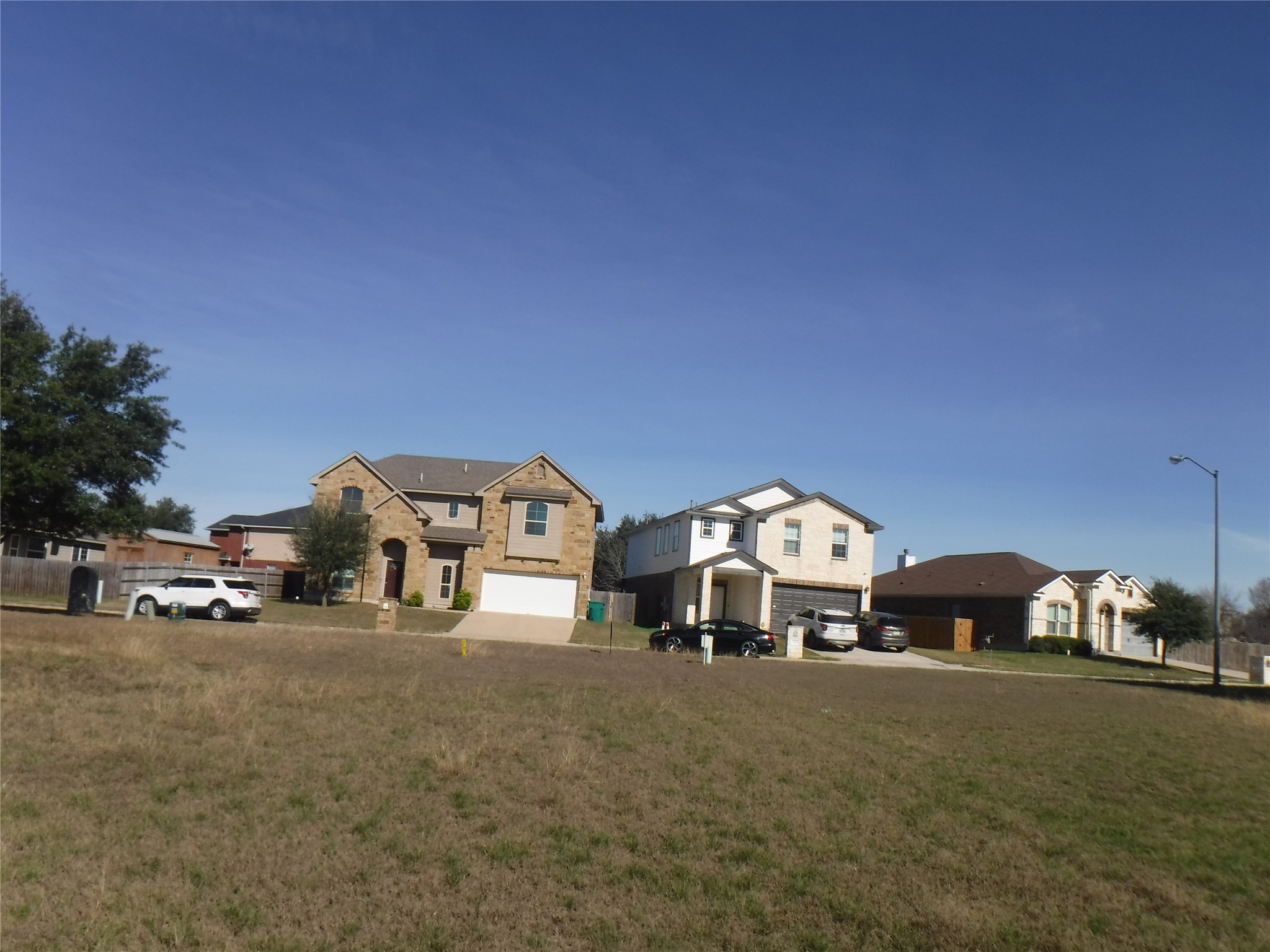317 Gettysburg Loop Elgin, TX 78621 - Photo 3 of 14 View of front of house featuring a residential view, an attached garage, a front yard, and driveway