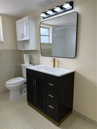 a bathroom with a toilet sink and mirror