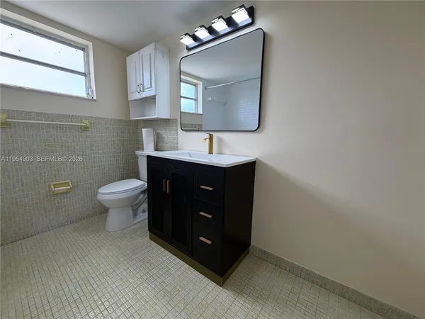 a bathroom with a sink toilet and mirror