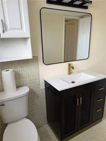 a bathroom with a sink toilet and window