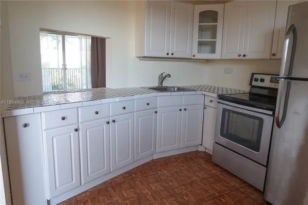 a kitchen with granite countertop white cabinets and stainless steel appliances