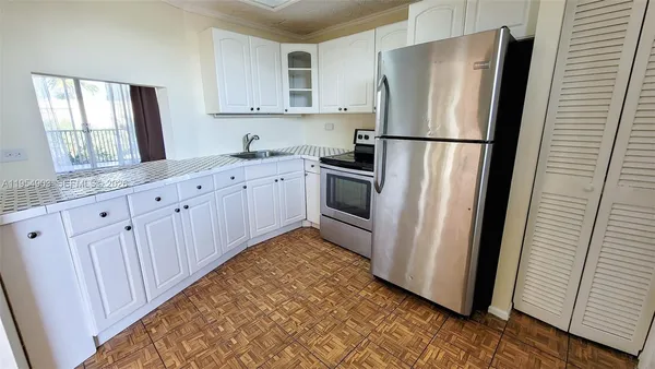 a kitchen with granite countertop cabinets appliances and a window