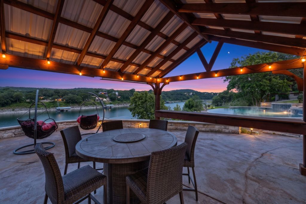 10800 Beach Road Leander, TX 78641 - Photo 31 of 39 A covered patio with string lights offers captivating lake views and a nearby pool, ideal for entertaining.