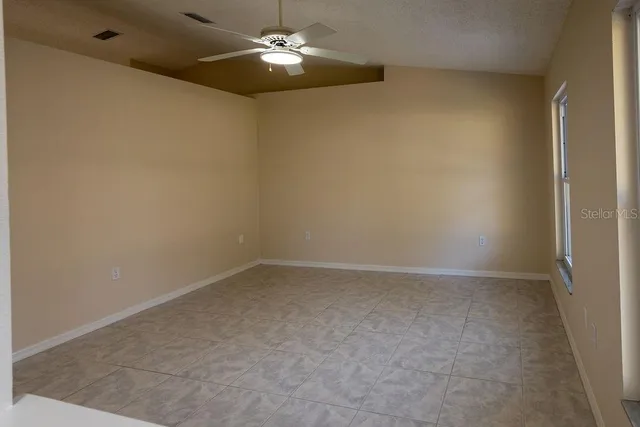an empty room with a chandelier fan and a chandelier fan