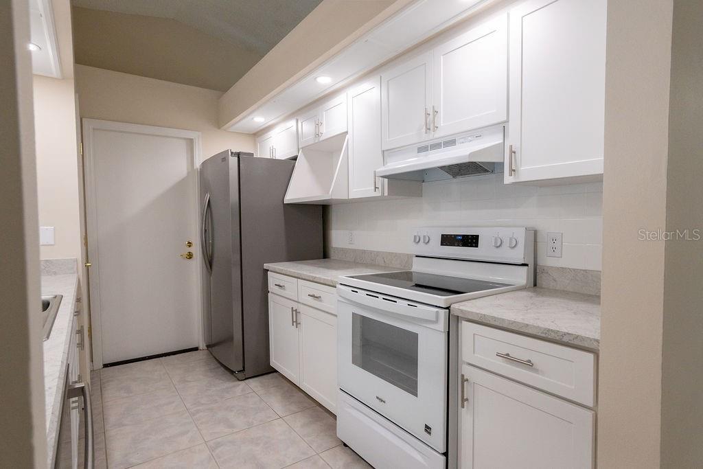 2405 Timbercreek Loop East Lakeland, FL 33805 - Photo 7 of 48 a kitchen with white cabinets and white appliances