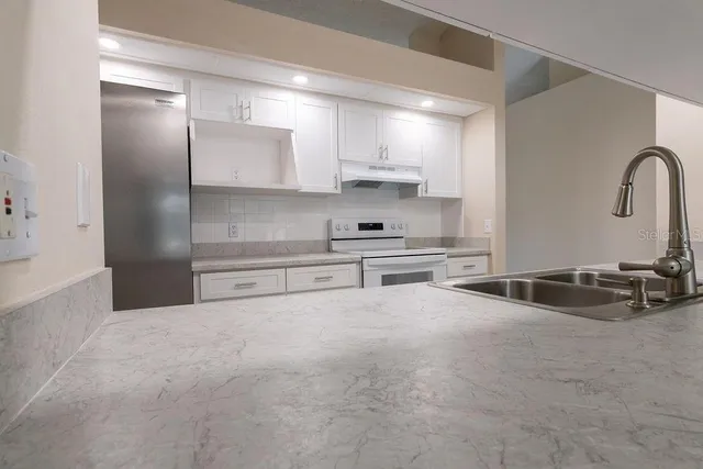 a kitchen with stainless steel appliances a sink and a stove top oven