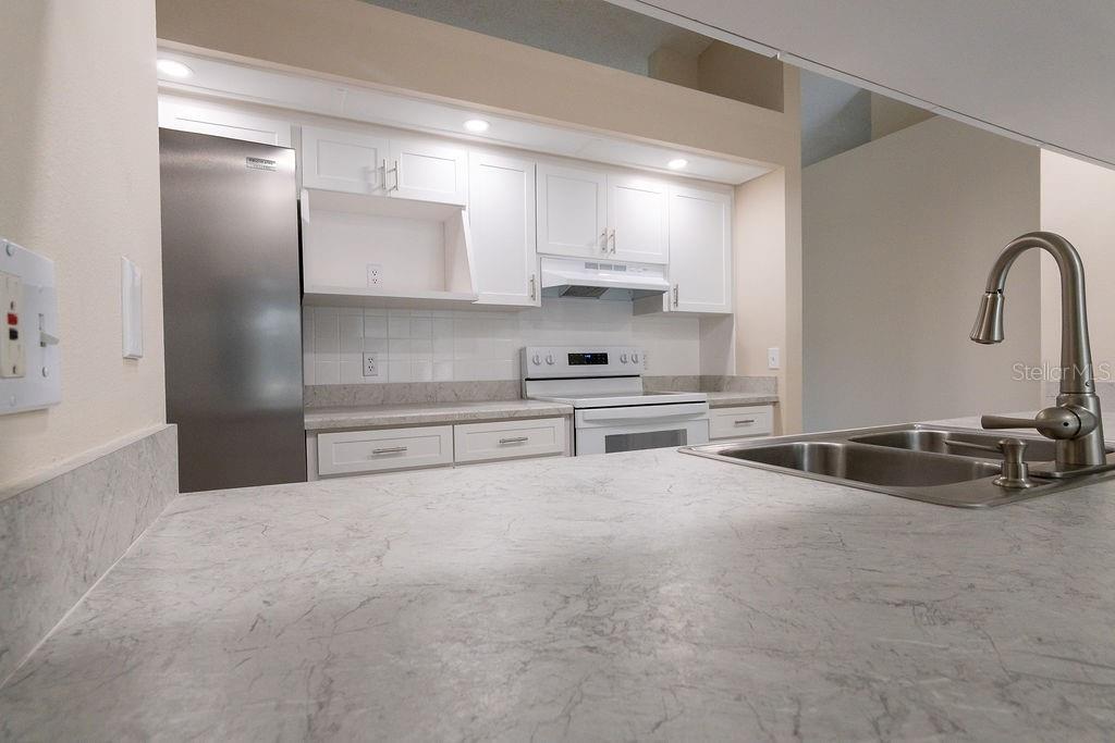 2405 Timbercreek Loop East Lakeland, FL 33805 - Photo 10 of 48 a kitchen with stainless steel appliances a sink and a stove top oven