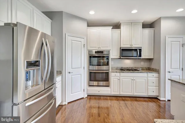 a kitchen with stainless steel appliances a refrigerator sink and microwave
