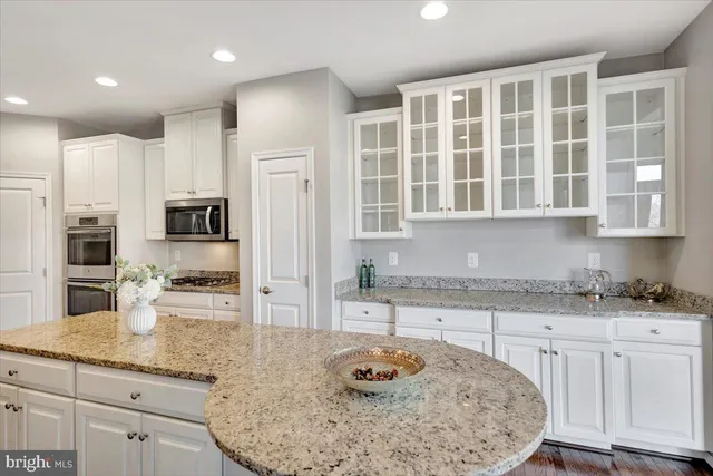 a kitchen with stainless steel appliances granite countertop a sink a stove and cabinets