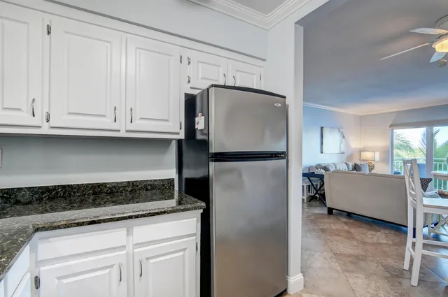 a kitchen with granite countertop a refrigerator and cabinets