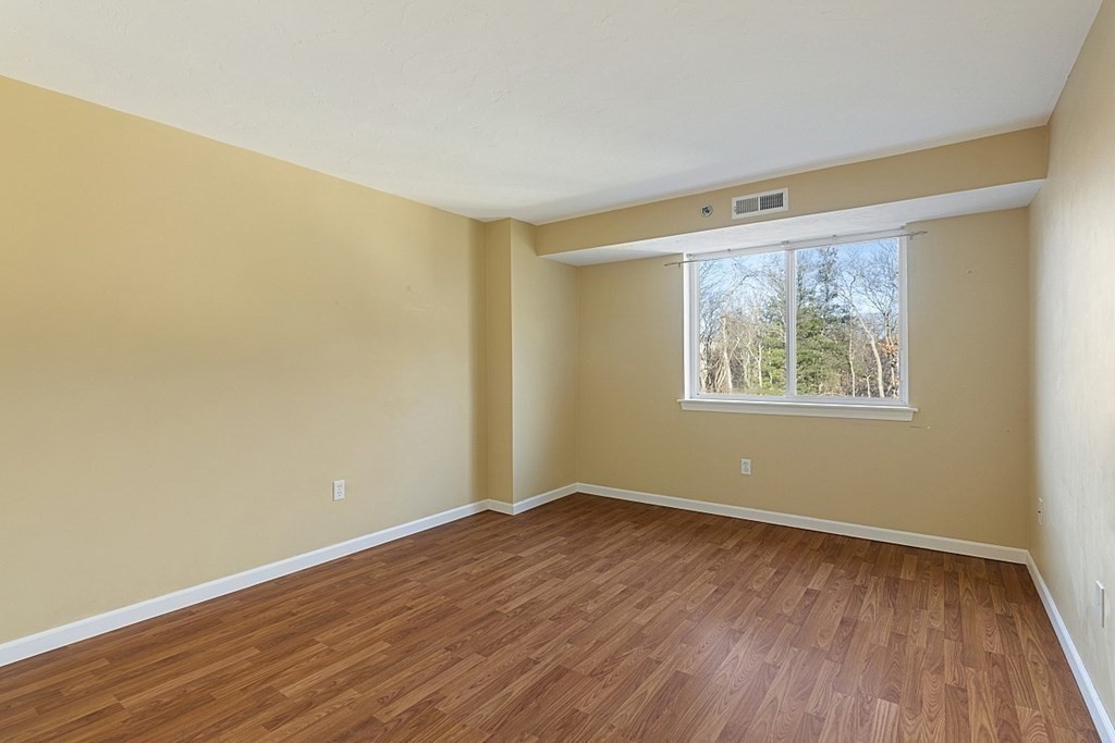 360 Littleton Road, Unit F2 Chelmsford, MA 01824 - Photo 11 of 27 a view of an empty room with wooden floor and a window