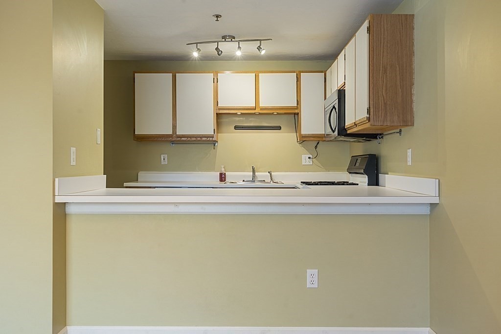 360 Littleton Road, Unit F2 Chelmsford, MA 01824 - Photo 8 of 27 a kitchen with kitchen island sink stove and cabinets