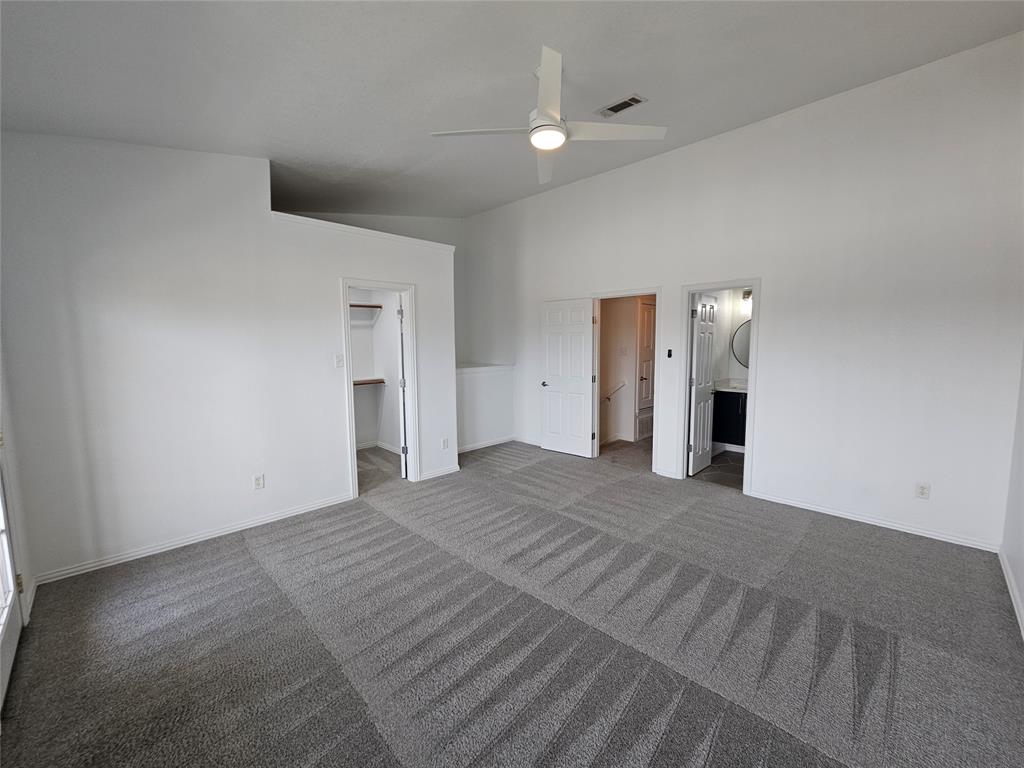 207 Starr Street Dallas, TX 75203 - Photo 15 of 28 Unfurnished bedroom with a spacious closet, carpet floors, ensuite bathroom, and a ceiling fan