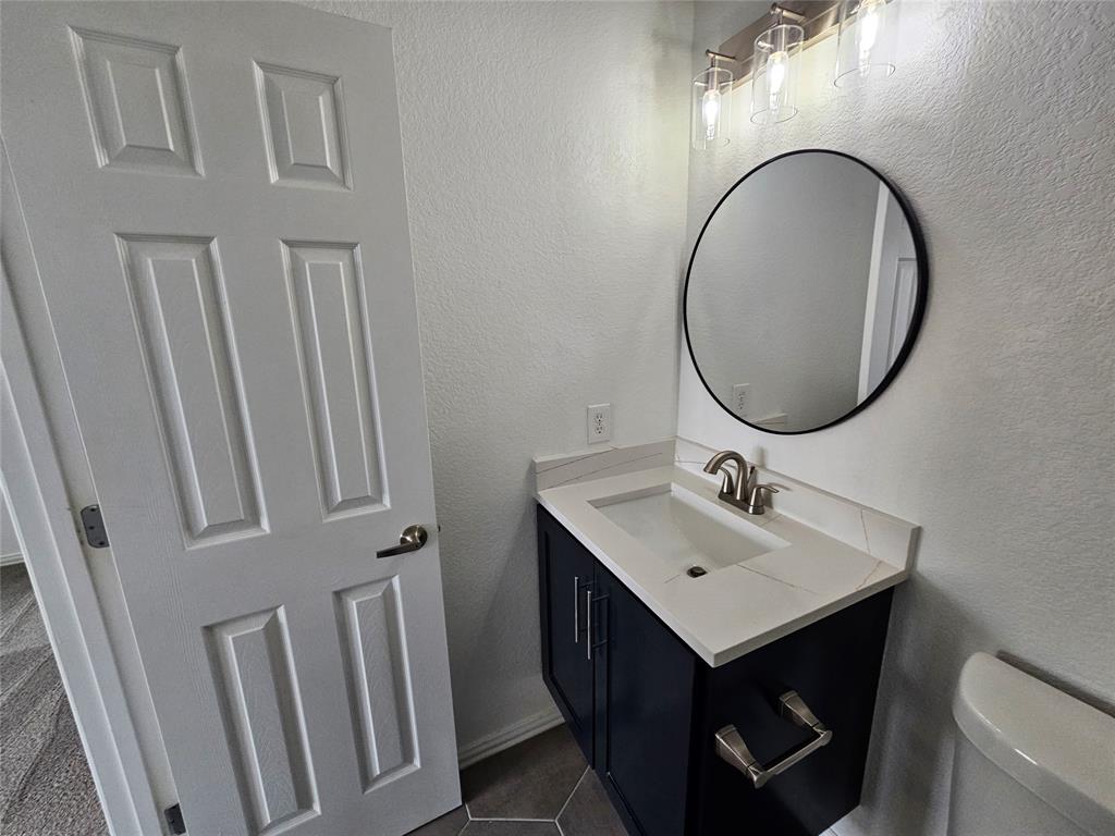 207 Starr Street Dallas, TX 75203 - Photo 18 of 28 Half bath featuring a textured wall and vanity