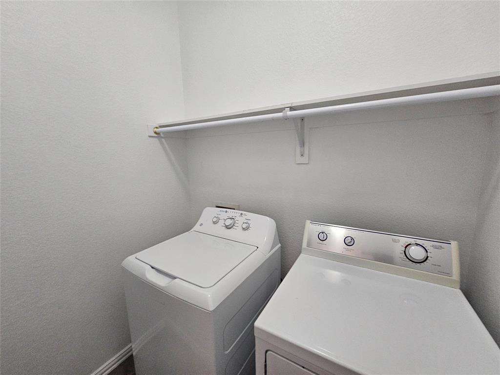 207 Starr Street Dallas, TX 75203 - Photo 19 of 28 Laundry area featuring a textured wall and washer and dryer