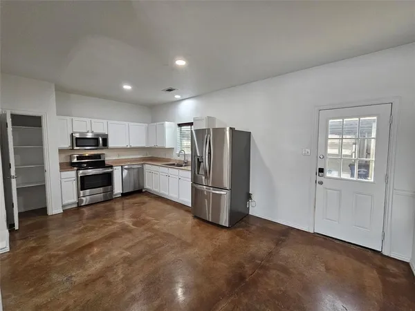 a kitchen with stainless steel appliances a refrigerator and a stove top oven