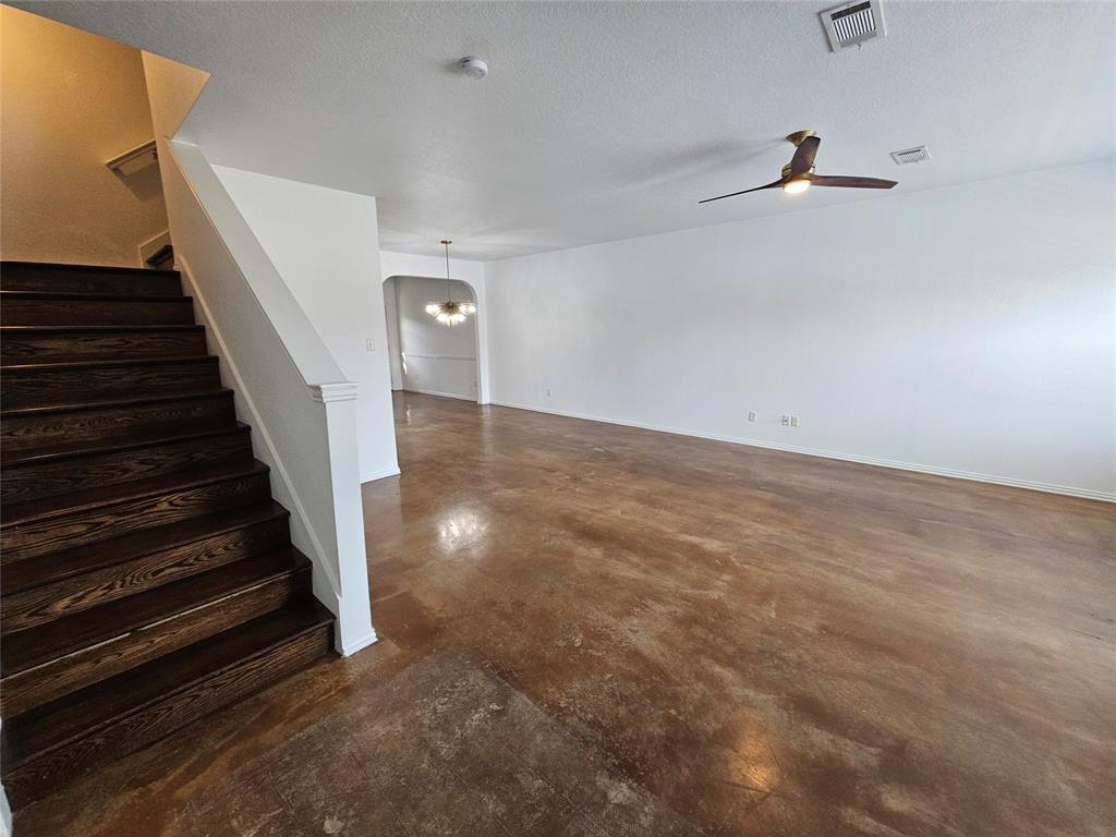 207 Starr Street Dallas, TX 75203 - Photo 9 of 28 Staircase with finished concrete floors, ceiling fan, hanging lights, arched walkways, and a textured ceiling