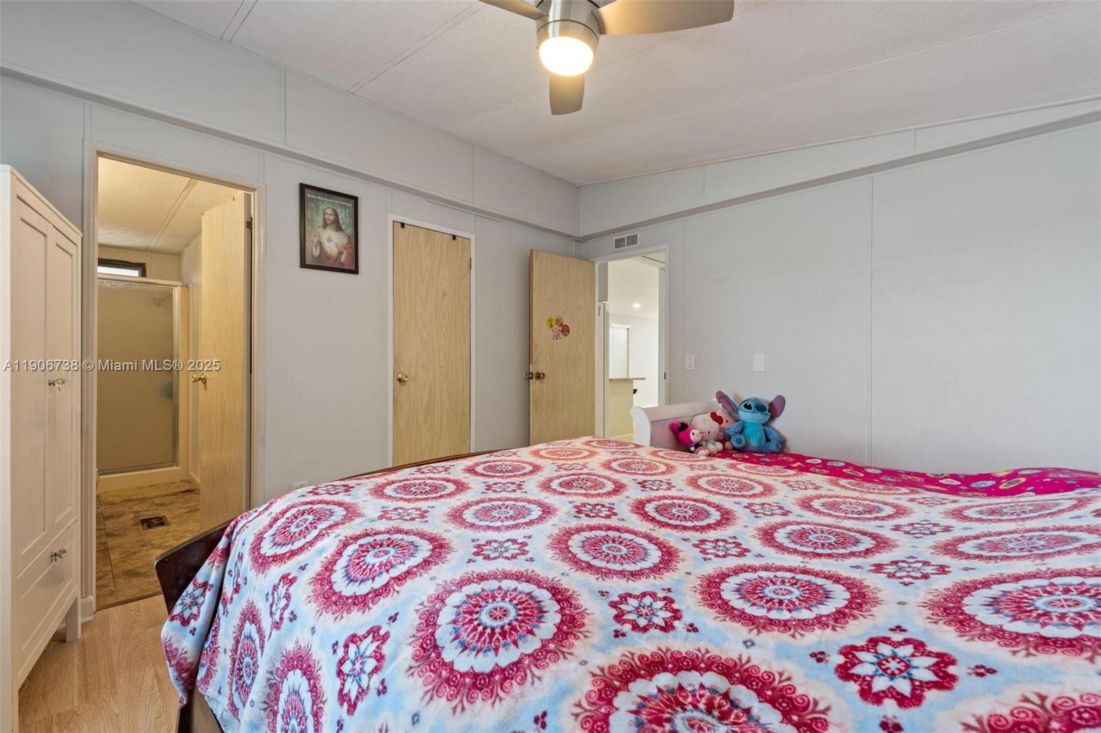 5305 Northwest 202nd Terrace Miami Gardens, FL 33055 - Photo 19 of 40 a bedroom with a large bed and a chandelier