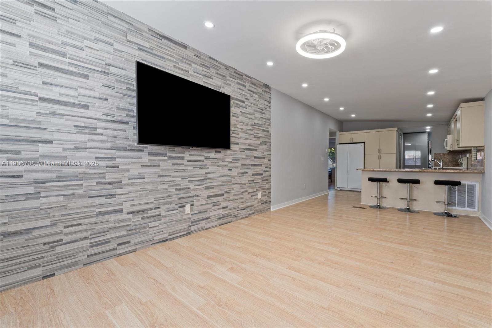 5305 Northwest 202nd Terrace Miami Gardens, FL 33055 - Photo 6 of 40 a living room with stainless steel appliances kitchen island furniture a flat screen tv and kitchen view