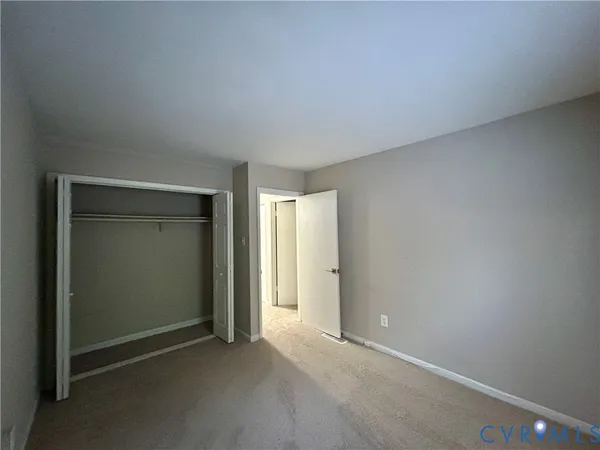 an empty room with closet and wooden door