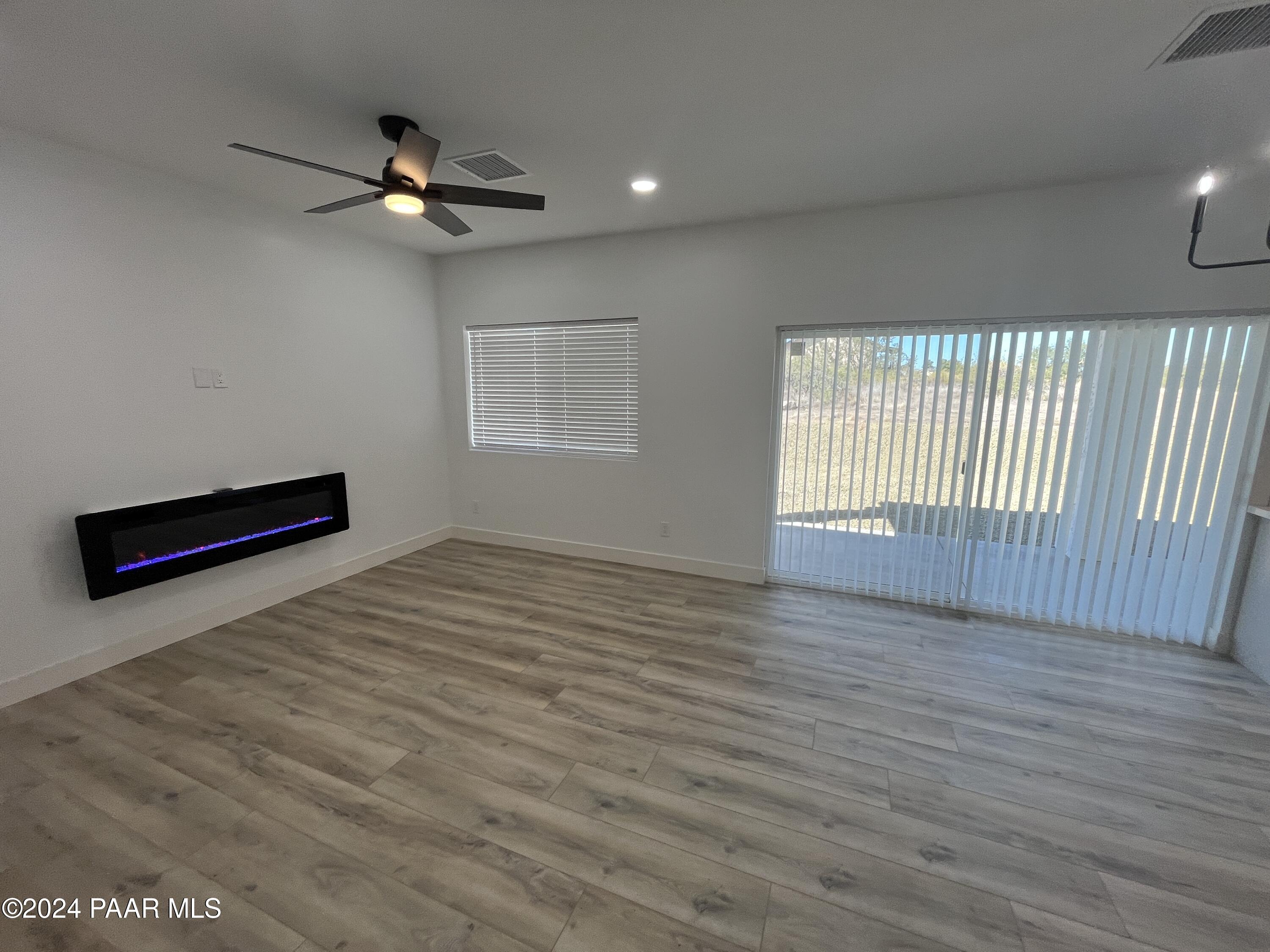 15630 Oasis Drive Mayer, AZ 86333 - Photo 22 of 29 an empty room with wooden floor fan and windows