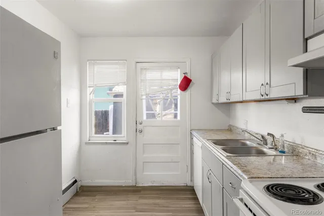 a kitchen with a refrigerator sink and white cabinets