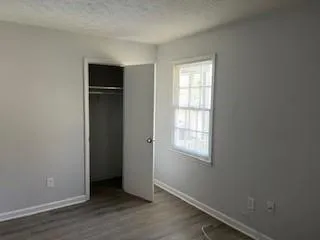 an empty room with wooden floor and a window