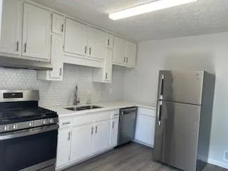 a kitchen with white cabinets and white appliances