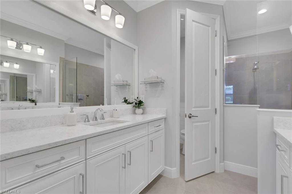2194 Marquesa Circle Naples, FL 34112 - Photo 16 of 38 a bathroom with a double vanity sink and mirror