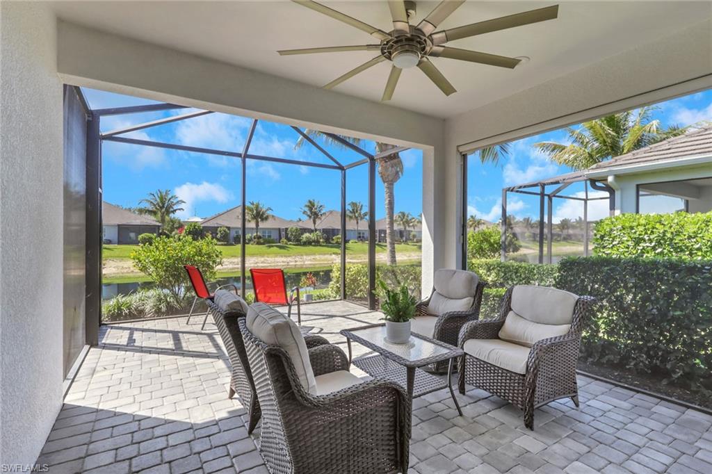 2194 Marquesa Circle Naples, FL 34112 - Photo 21 of 38 a dining room with furniture a flat screen tv and a floor to ceiling window