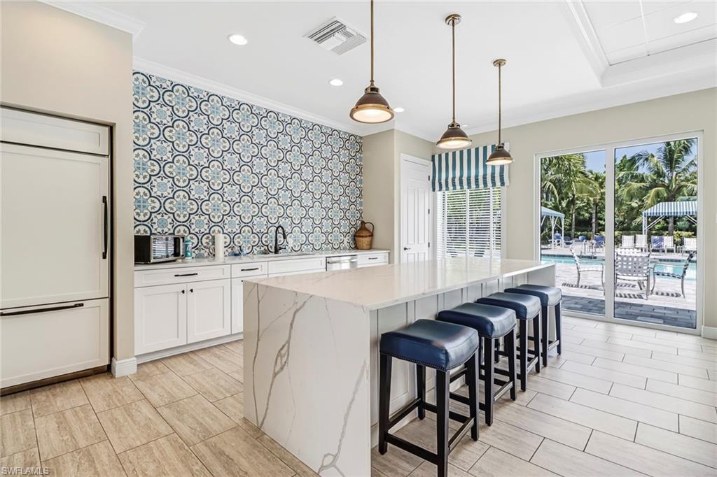 2194 Marquesa Circle Naples, FL 34112 - Photo 31 of 38 a kitchen with granite countertop cabinets a dining table and a chandelier