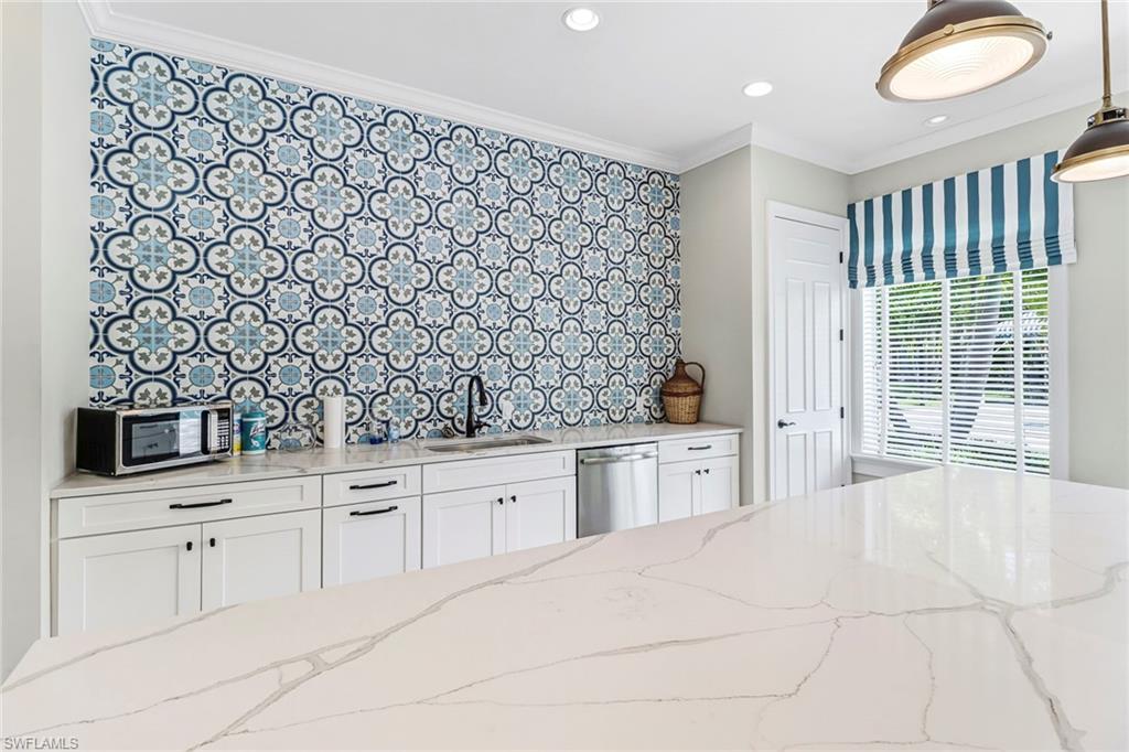 2194 Marquesa Circle Naples, FL 34112 - Photo 32 of 38 a large white kitchen with a sink and dishwasher with white cabinets