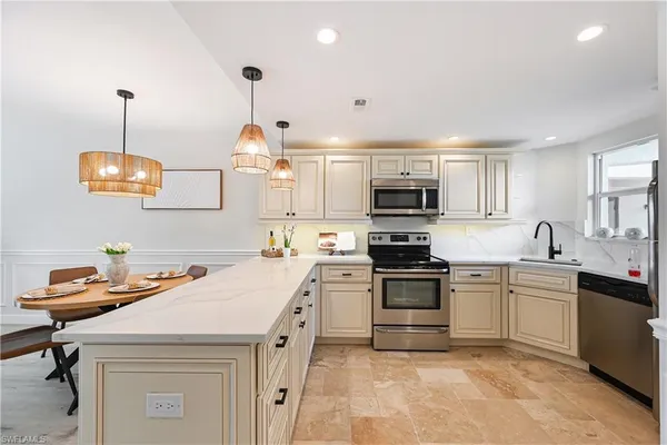 a kitchen with a sink a stove and chairs