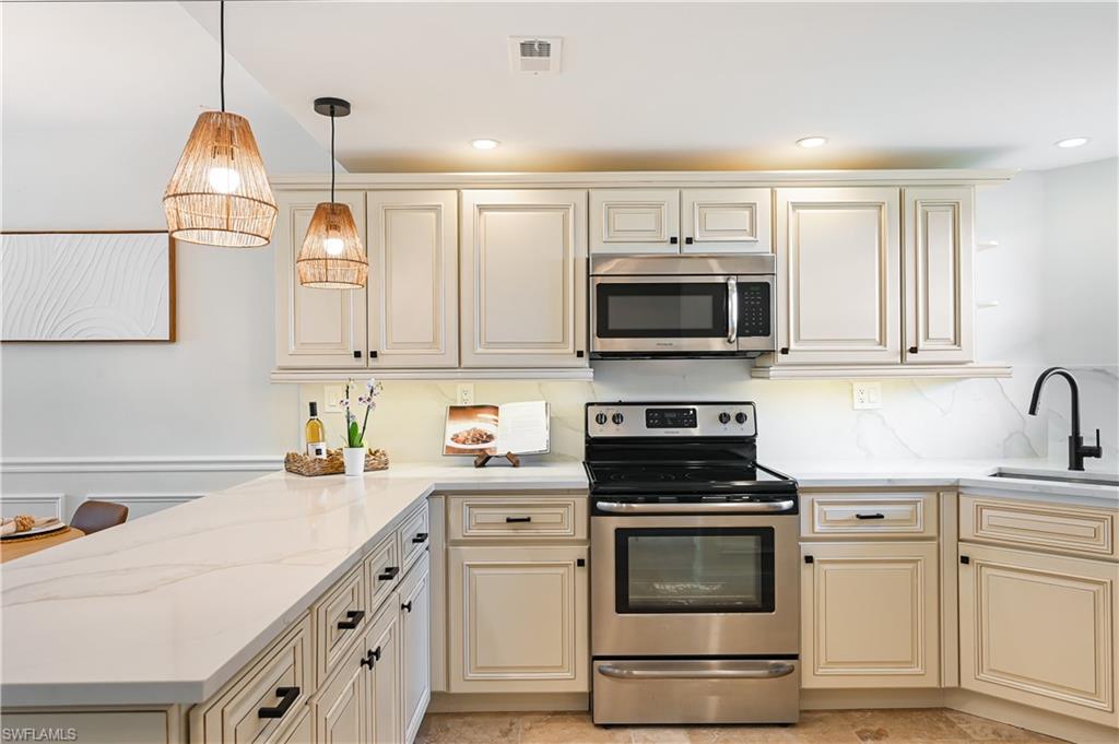 190 Pebble Beach Boulevard, Unit 202 Naples, FL 34113 - Photo 35 of 36 a kitchen with white cabinets and appliances