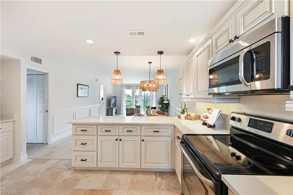 a kitchen with white cabinets and appliances