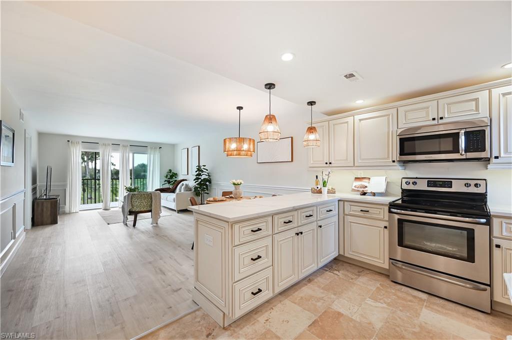 190 Pebble Beach Boulevard, Unit 202 Naples, FL 34113 - Photo 36 of 36 a large white kitchen with stainless steel appliances granite countertop a stove and a sink