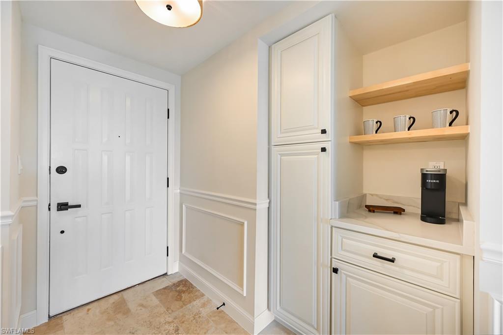 190 Pebble Beach Boulevard, Unit 202 Naples, FL 34113 - Photo 13 of 36 a view of kitchen with cabinets and wooden floor