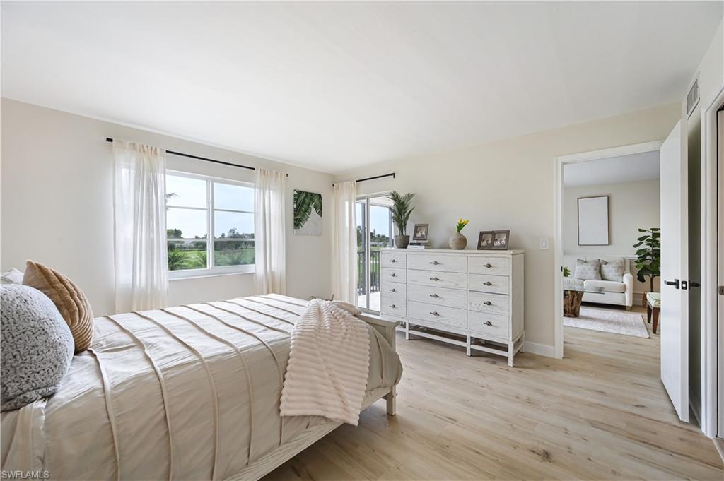 190 Pebble Beach Boulevard, Unit 202 Naples, FL 34113 - Photo 14 of 36 a bedroom with a bed and wooden floor