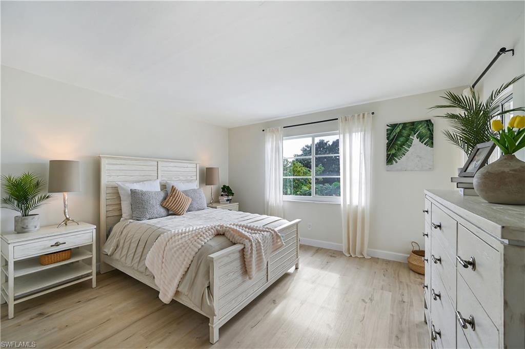 190 Pebble Beach Boulevard, Unit 202 Naples, FL 34113 - Photo 17 of 36 a bedroom with a bed potted plant with the window