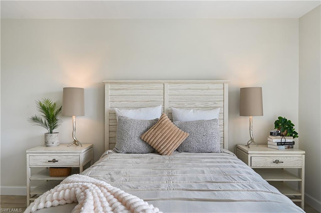 190 Pebble Beach Boulevard, Unit 202 Naples, FL 34113 - Photo 18 of 36 a bedroom with a bed and a potted plant