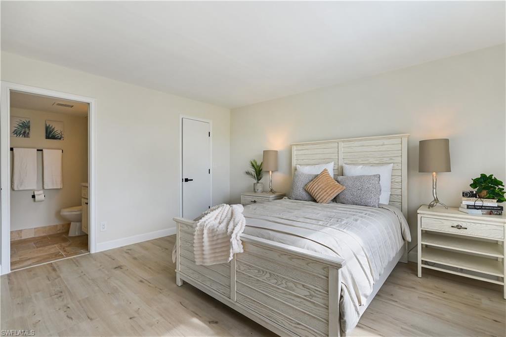 190 Pebble Beach Boulevard, Unit 202 Naples, FL 34113 - Photo 19 of 36 a bedroom with bed and wooden floor