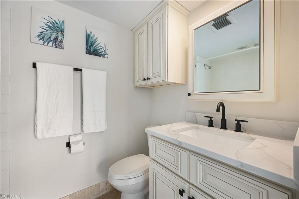 190 Pebble Beach Boulevard, Unit 202 Naples, FL 34113 - Photo 22 of 36 a bathroom with a toilet sink and mirror