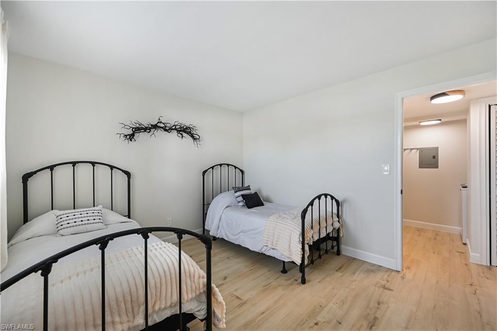 190 Pebble Beach Boulevard, Unit 202 Naples, FL 34113 - Photo 23 of 36 a view of a bedroom with two beds and wooden floor