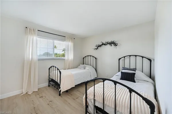 a view of a bedroom with two beds and wooden floor