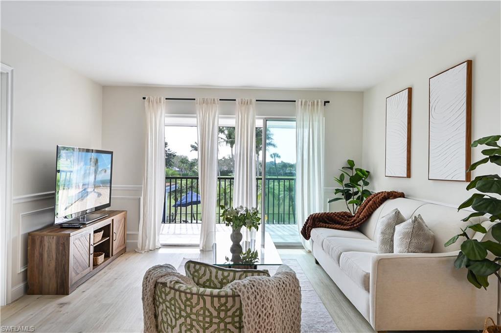 190 Pebble Beach Boulevard, Unit 202 Naples, FL 34113 - Photo 3 of 36 a living room with furniture fireplace and a flat screen tv