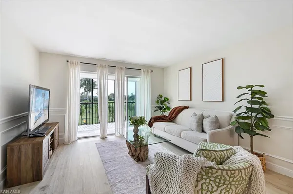 a living room with furniture a large window and a flat screen tv