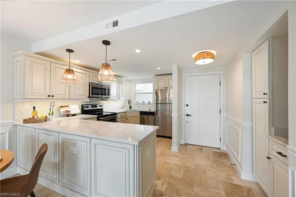 a kitchen with stainless steel appliances a refrigerator sink and cabinets
